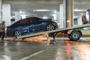 Grúa plataforma sacando coche averiado de parking subterráneo - Servicio 24h Barcelona